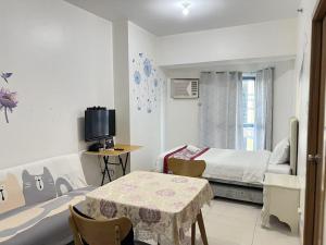 a bedroom with a bed and a table and a television at Dreamy Sunset Bay in Manila