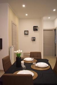 a dining room with a black table and chairs at Maddy Home - Moderno appartamento a Torino in Turin