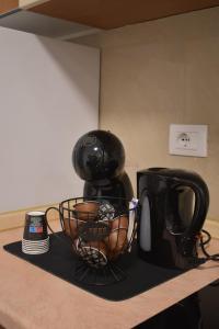 a black coffee maker on a counter next to a cup at Maddy Home - Moderno appartamento a Torino in Turin