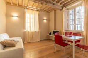 a living room with a table and red chairs at Relais Villa Zaccaria in Bordolano