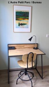 a wooden desk with a lamp and a chair at Le Petit Parc in Colmar