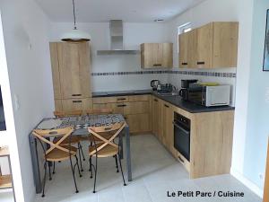 a kitchen with a table with chairs and a microwave at Le Petit Parc in Colmar