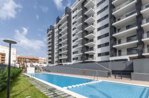 a swimming pool in front of a large building at AG El Alamo in Playa de Gandia