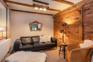 a living room with a leather couch and a brick wall at Große Use in Benz