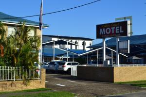 een motelbord voor een parkeerplaats bij Calico Court Motel in Tweed Heads
