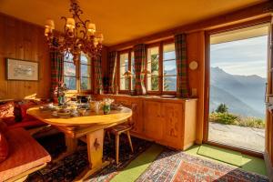 a dining room with a table and a large window at Chalet Bouquetins 7 personnes ski in ski out in Gryon