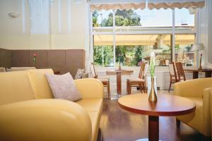 a restaurant with yellow couches and tables and chairs at BRISTOL Hotel Opatija in Opatija