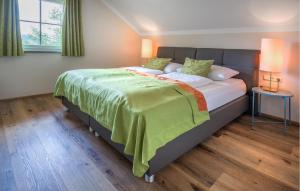 a bedroom with a large bed with a green blanket at Stunning Home In Mariapfarr With Sauna in Mariapfarr