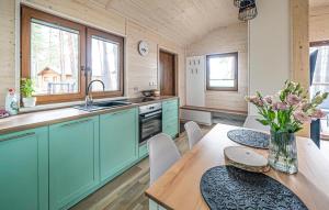 una cocina con armarios verdes y una mesa con un jarrón de flores en Awesome Home In Borsk With Wifi, en Borsk