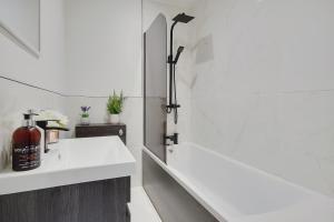 a bathroom with a white tub and a sink at Columbia Road in Bournemouth