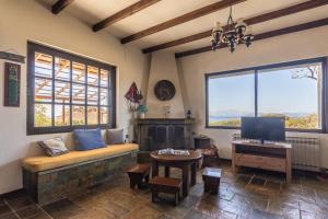 een woonkamer met een bank, een tv en 2 ramen bij Evia Escape in Vathírrevma