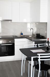 a kitchen with white cabinets and a table and a sink at Los Cristianos Aqua Viva in Los Cristianos