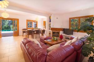 a living room with a leather couch and a table at Villa Calma by Mallorca Infinity in Santa Ponsa