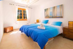 a bedroom with a large blue bed with towels on it at Villa Calma by Mallorca Infinity in Santa Ponsa