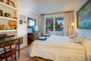 a bedroom with a bed and a desk and a window at Villa Vistas Dragonera by Mallorca Infinity in Andratx