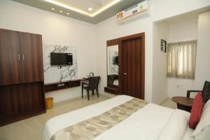 a bedroom with a bed and a desk and a tv at Rajmoti hotel & Restro in Udaipur