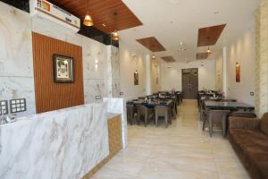 a restaurant with tables and chairs in a room at Rajmoti hotel & Restro in Udaipur