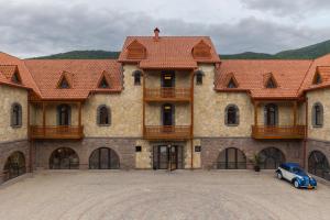 una macchina blu parcheggiata di fronte a un grande edificio di Old Ijevan Boutique Hotel a Ijevan