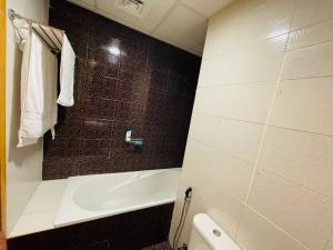 a bathroom with a bath tub and a toilet at Big Studio Apartment in Dubai Marina Walking to JBR Beach, Cruise and DMCC Metro in Dubai