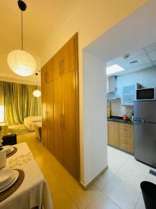 a kitchen and living room with a table and a refrigerator at Big Studio Apartment in Dubai Marina Walking to JBR Beach, Cruise and DMCC Metro in Dubai