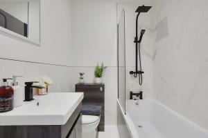 a white bathroom with two sinks and a toilet at Columbia Road in Bournemouth