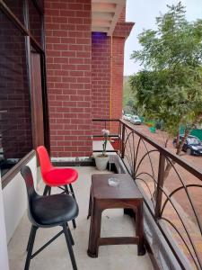 a balcony with a red chair and a table at Prem villas homestay in Tājganj