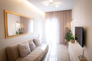 a living room with a white couch and a mirror at Sea Salt Studio in Marsalforn