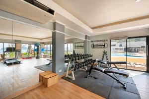 a gym with treadmills and exercise equipment in a house at Thavorn Beach Village Resort & Spa Phuket in Kamala Beach