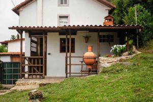 a small white house with a large vase on the porch at Casa Yamba in Montojo