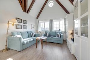 a living room with a blue couch and a table at Giebel Alte Muehle in Keitum