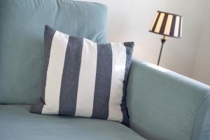 a striped pillow on a blue couch with a lamp at Giebel Alte Muehle in Keitum