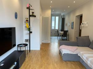 un soggiorno con un divano e una TV di Comoluxhouse- Intero appartamento a Como