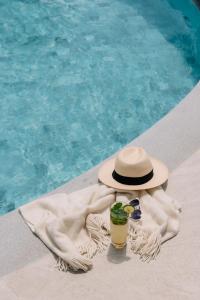 a hat and a drink on a towel next to a swimming pool at InterContinental Bangkok by IHG in Bangkok