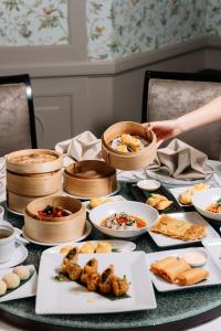 a table topped with plates and bowls of food at InterContinental Bangkok by IHG in Bangkok