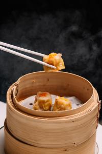 a wooden bowl of food with chopsticks in it at InterContinental Bangkok by IHG in Bangkok