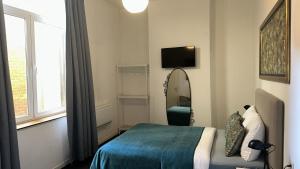 a bedroom with a bed and a mirror and a window at Happy Home in Brussels