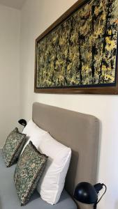 a painting above a bed with pillows on it at Happy Home in Brussels