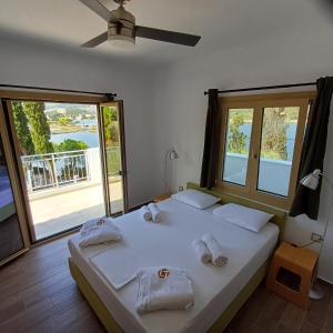 ein Schlafzimmer mit einem großen Bett, auf dem Handtücher liegen in der Unterkunft Skiathos Lagoterra Apartments in Skiathos-Stadt