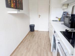 a kitchen with white counters and a wooden floor at Beautiful Apartment in Velbert in Velbert +7 photos