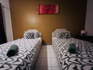 Dos camas una al lado de la otra en una habitación. en The UrBan Selesa Hillhomes, Bukit Tinggi Bentong, en Bentong 12 fotos más