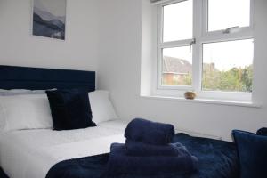 une chambre avec un lit, une chaise et une fenêtre dans l'établissement Charming 3 Bedroom Apartment in Wythenshawe Convenient for Manchester Airport and City Centre Free Parking, à Wythenshawe