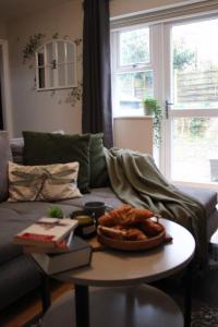 un salon avec un canapé avec une table dans l'établissement Charming 3 Bedroom Apartment in Wythenshawe Convenient for Manchester Airport and City Centre Free Parking, à Wythenshawe