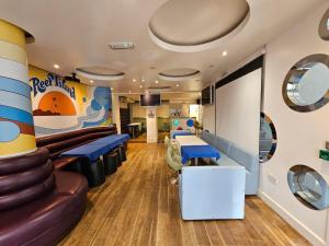 a waiting room with blue chairs and a slide at Reef Lodge in Newquay