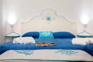 a blue bed with two white towels on it at Monolocale Iride in Santa Teresa Gallura