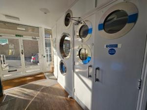 a hallway with four washing machines in a building at Reef Lodge in Newquay +44 photos
