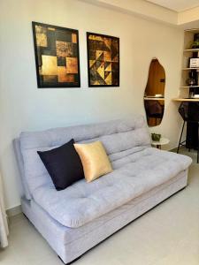 a couch in a living room with paintings on the wall at Paradise at your fingertips in Cabedelo