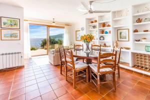 a dining room with a table and chairs and a window at Casita Marinera Sant Elm by Mallorca Infinity in Sant Elm