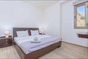 a bedroom with a bed with two lamps and a window at Yara's 2BR Terrace Retreat in Fārayyā