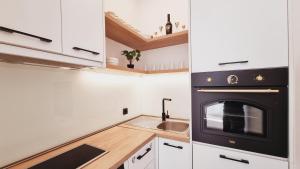 a small kitchen with a stove and a sink at White Pearl, Casa Al Mare in Rafailovici