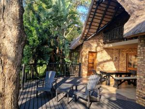 un patio con sillas, una mesa y un árbol en Kruger Park Lodge - Private Villa 514, en Hazyview